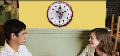 Woman and Man Eating and Laughing while a clock glows steadily in the background